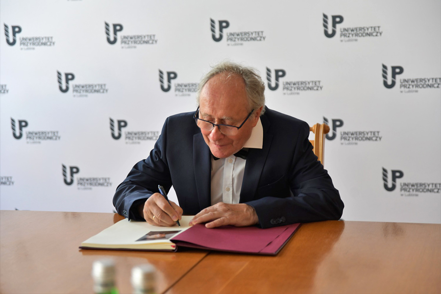 Prof. Kotecki złożył podpis w księdze pamiątkowej uczelni