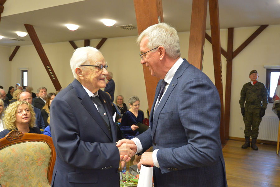 Rektor UPWr Jarosław Bosy jubilatowi ofiarował 121-letnią grafikę z wrocławski ratuszem