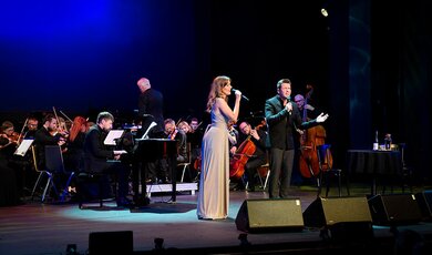 Zofia Nowakowska i Krzysztof Iwaneczko śpiewają, w tle orkiestra